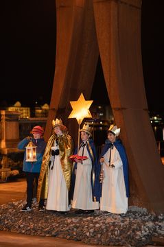 Sternsingerinnen und Sternsinger mit Stern und Laterne am Abend in Zürich