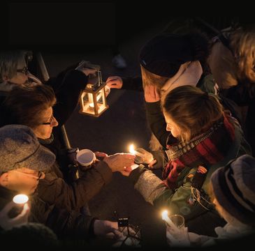 Menschen geben das Licht mit Kerzen und einer Laterne weiter (Sujet 2017)